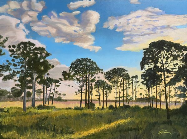 View of the Pines at Sunset: painting of tall pine trees over sunlit grass beneath a wide blue sky with billowing clouds.
